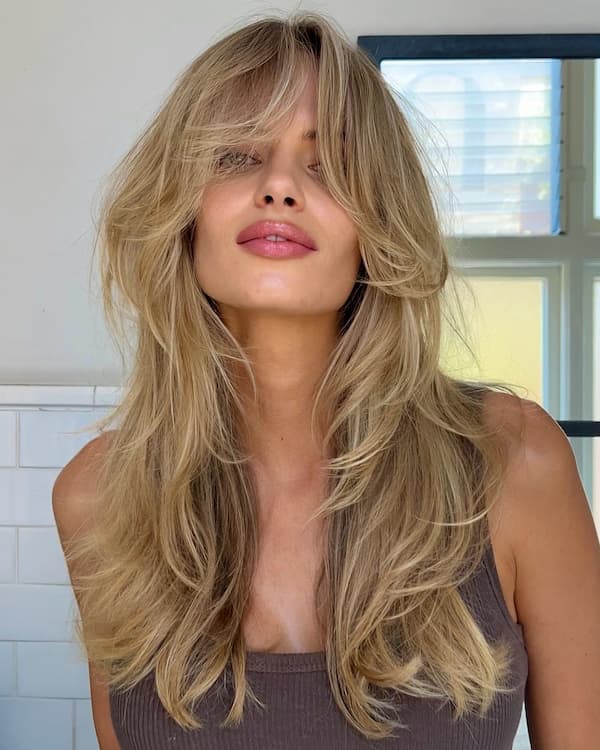 Long layered haircut with soft curtain bangs framing the face