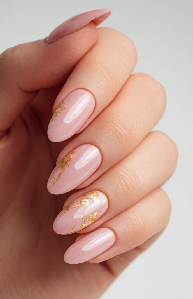 Long almond soft pink nails with scattered gold foil flakes