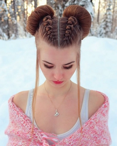 Front view of a woman with double braided space buns in the snow