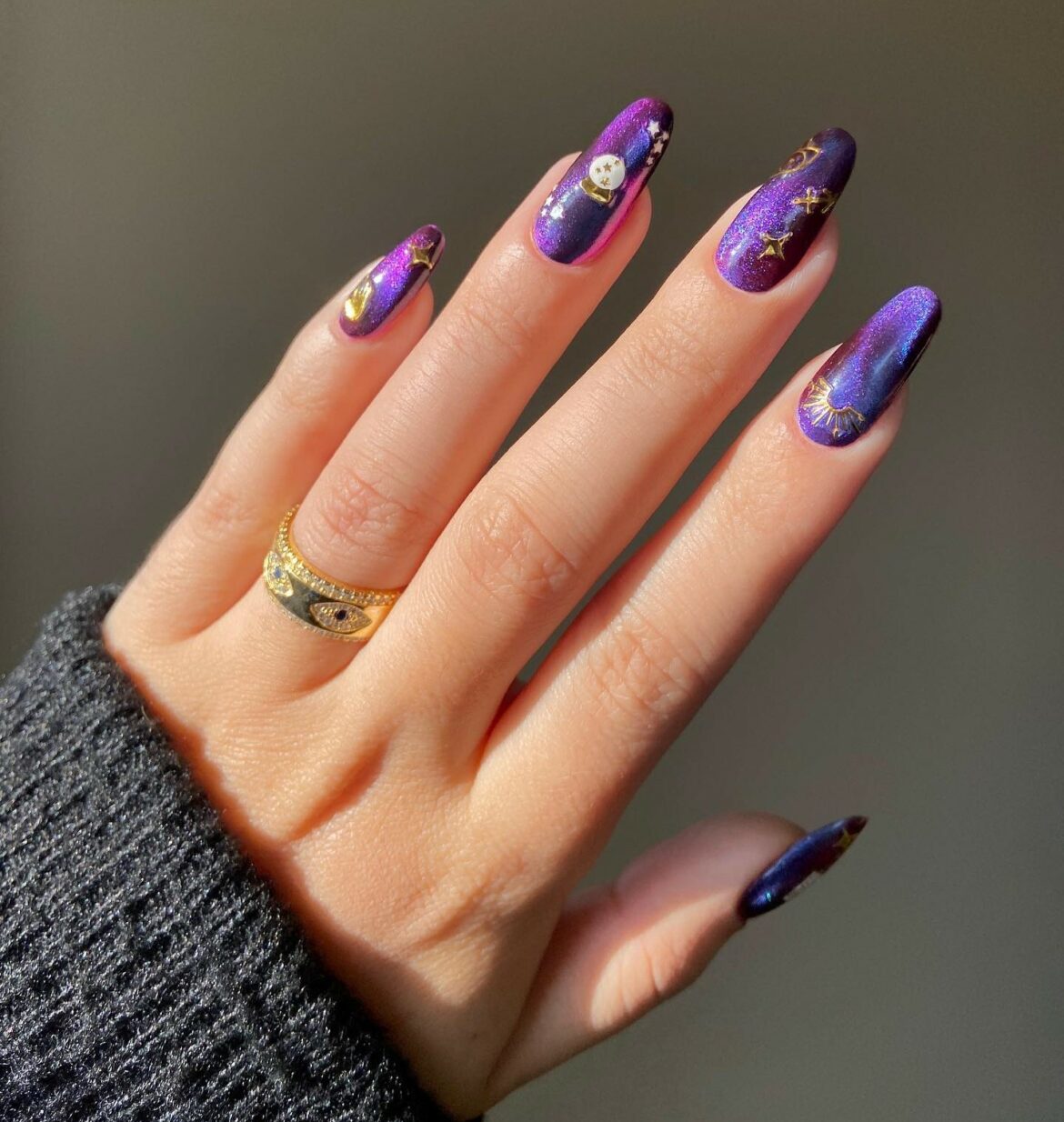Purple cat eye nails with gold star decals