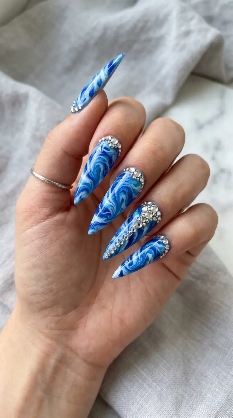 Stiletto nails with blue and white marble wave pattern