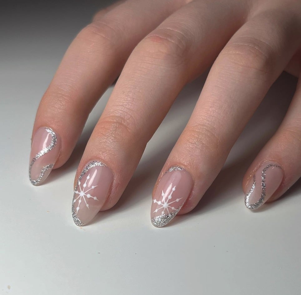 Subtle nude oval Christmas nails with silver glitter accents
