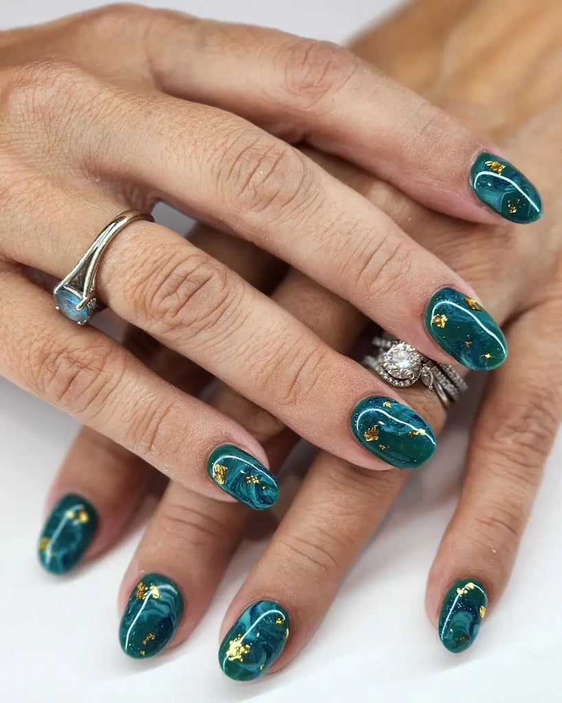 Deep teal nails with gold foil accents