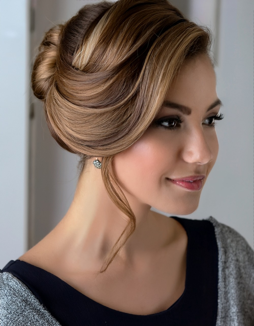 Modern Gibson tuck updo with a face-framing tendril on caramel brown hair
