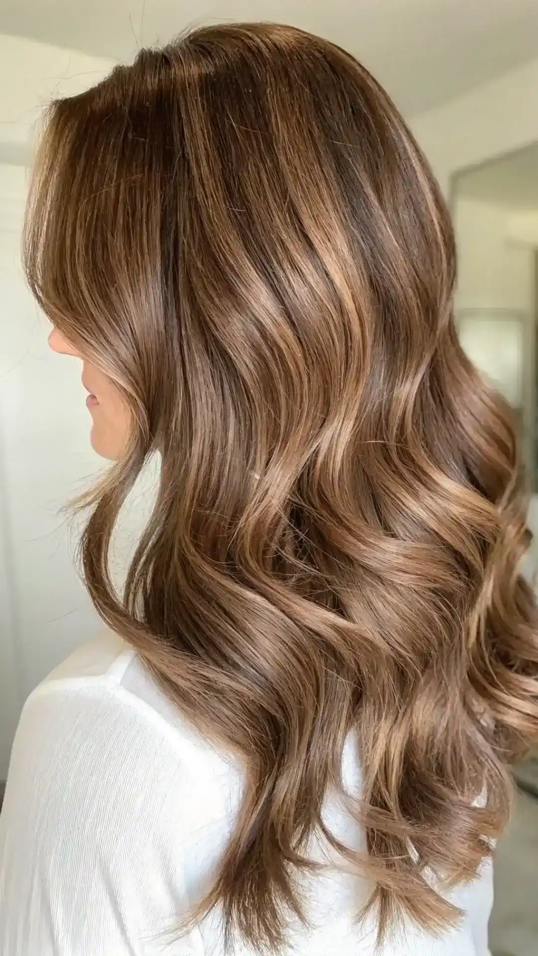 Side view of long layered hair with toffee caramel golden balayage