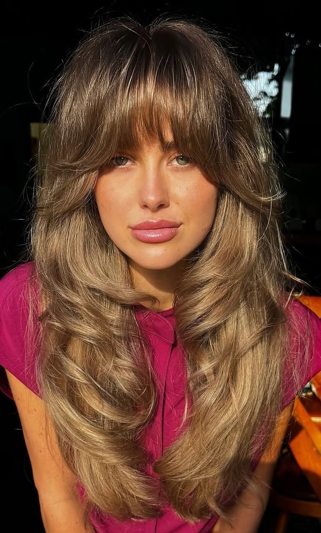 Long layered golden brown hair with curtain bangs
