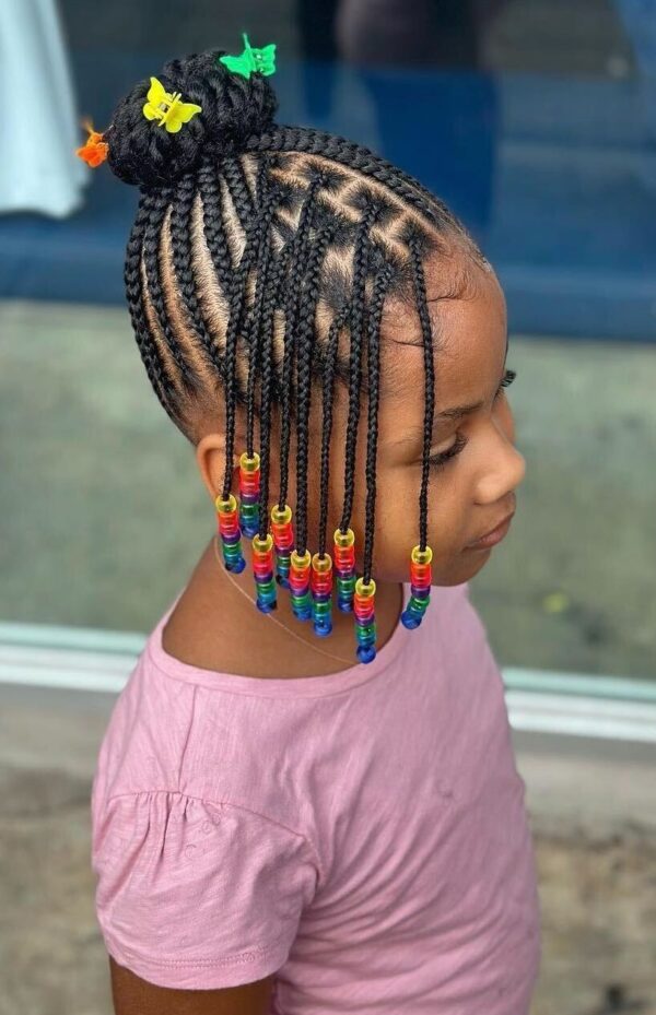 Little girl with cornrow boxer braids decorated with colorful rainbow beads and butterfly clips