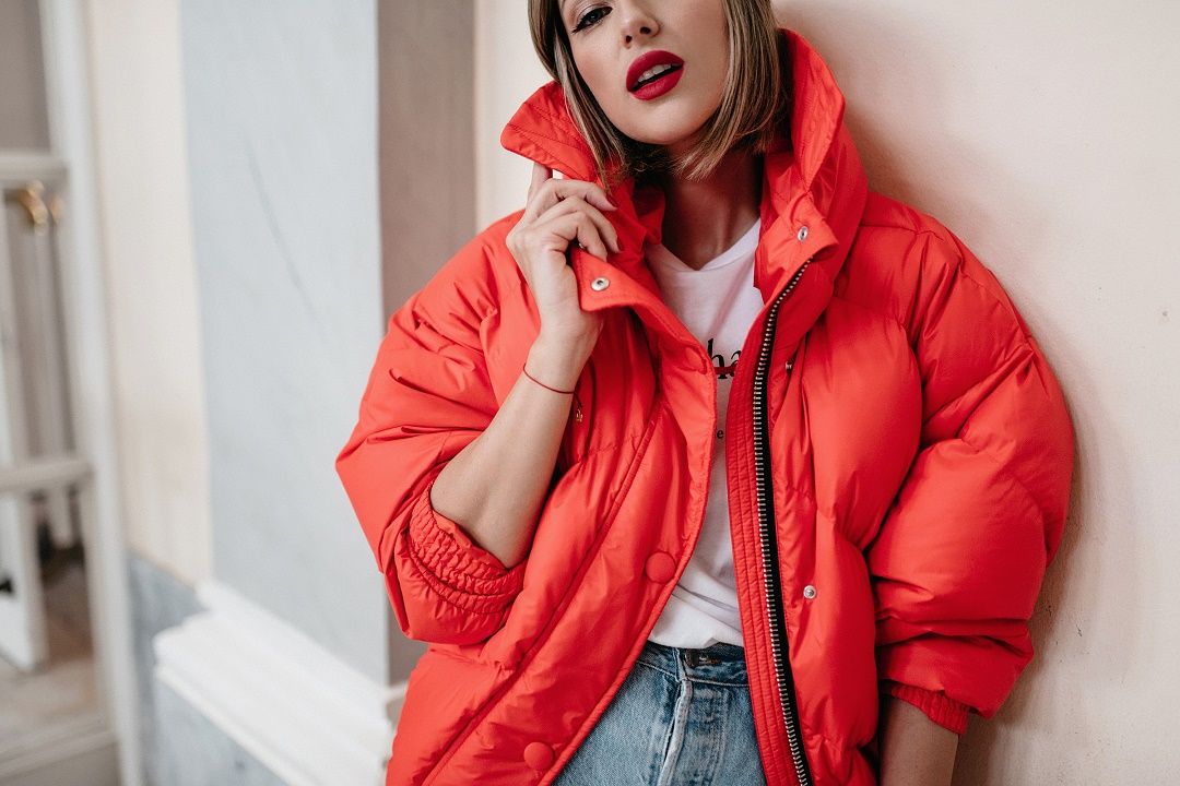 Woman wearing a red puffer jacket with black winter layers
