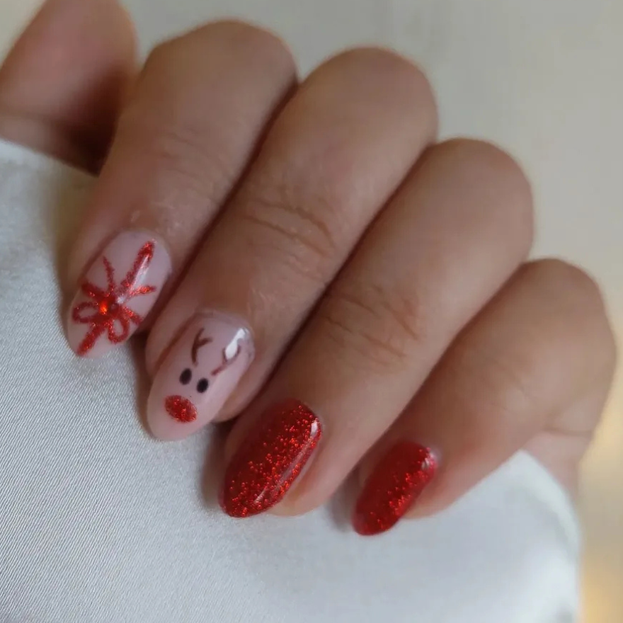Medium almond nails in red glitter with a reindeer face and bow accent art