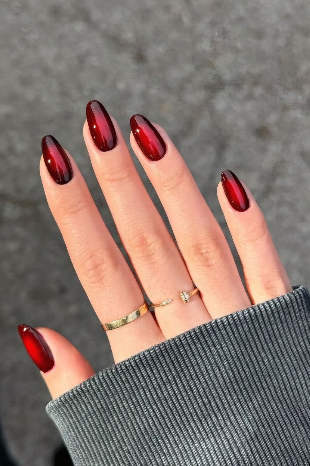 Black cherry aura nails with a glowing red center on almond nails