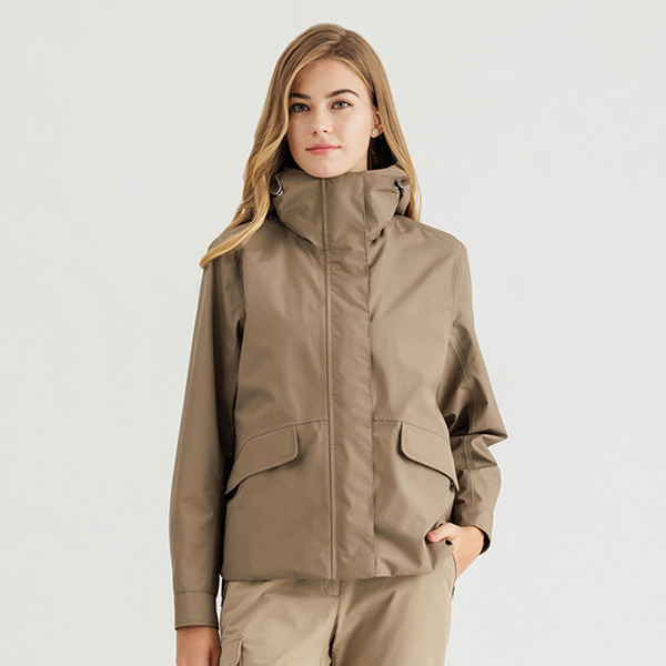 A taupe technical hooded jacket with flap pockets, worn with beige cargo pants.
