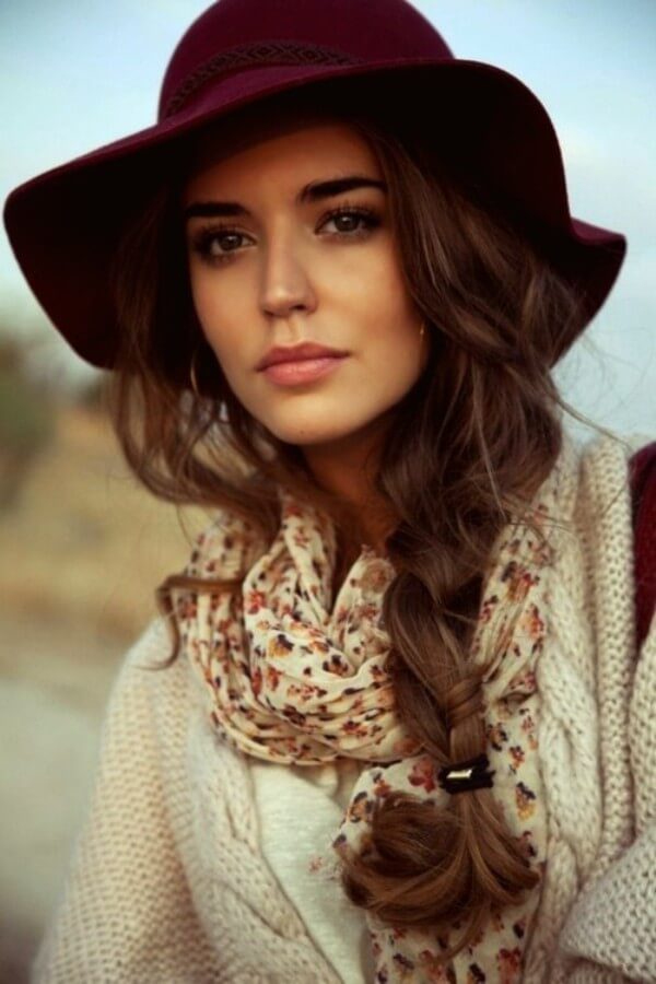 Woman in a burgundy floppy felt hat with a long side fishtail braid over her shoulder