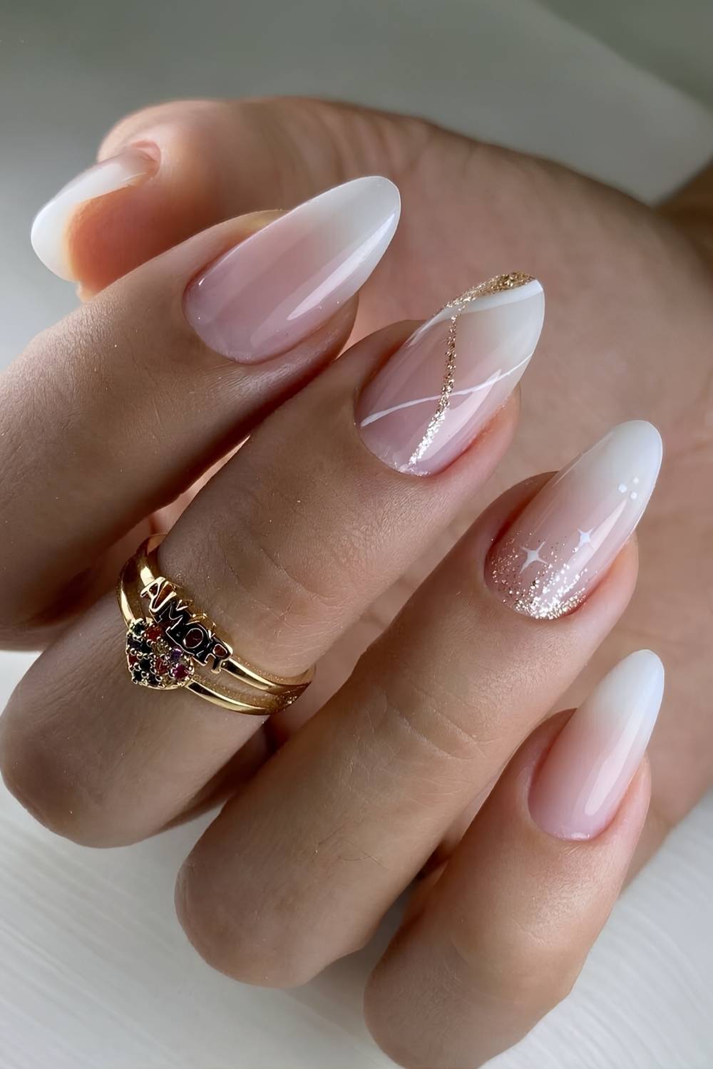 Short almond white nails with gold glitter and star accents
