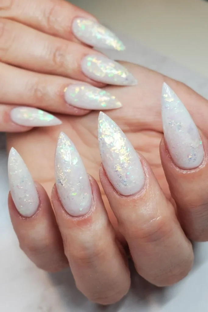 Stiletto nails in milky white with iridescent opal flakes