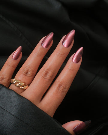 Short almond nails in berry wine with a rose-gold chrome sheen