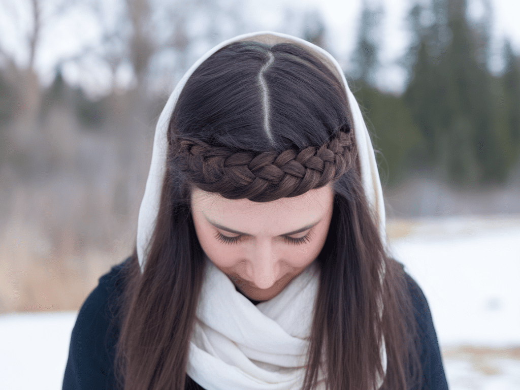 Woman with a dutch braided headband and a white winter snood in the snow