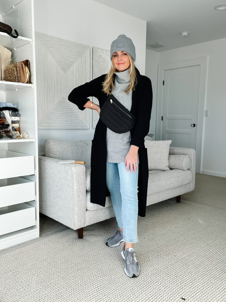 Woman in a long cardigan with mom jeans and sneakers