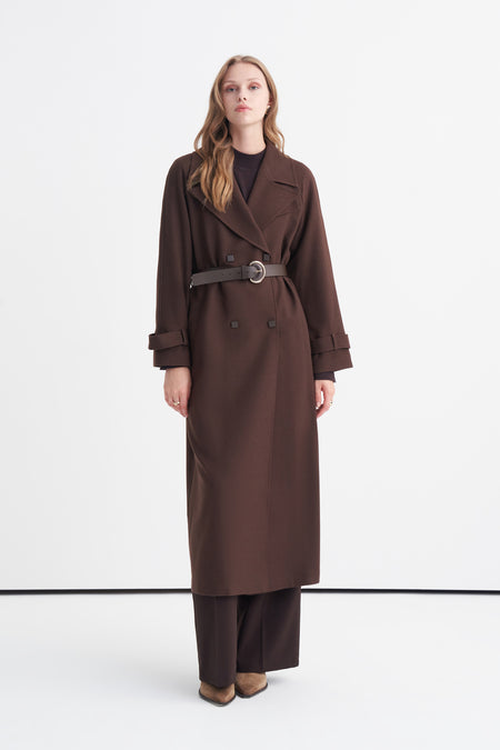 Chocolate brown belted double-breasted trench coat worn over tonal layers