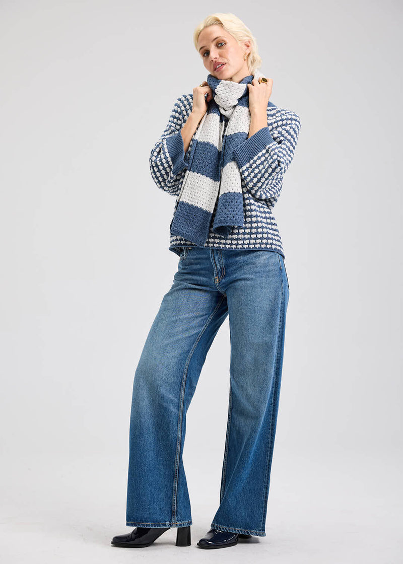 Navy merino knit sweater styled for layering with a tartan scarf