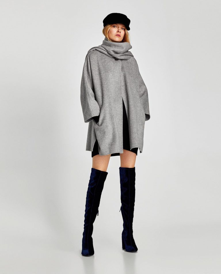 Grey cowl-neck wool cape with black baker boy cap and navy over-the-knee boots