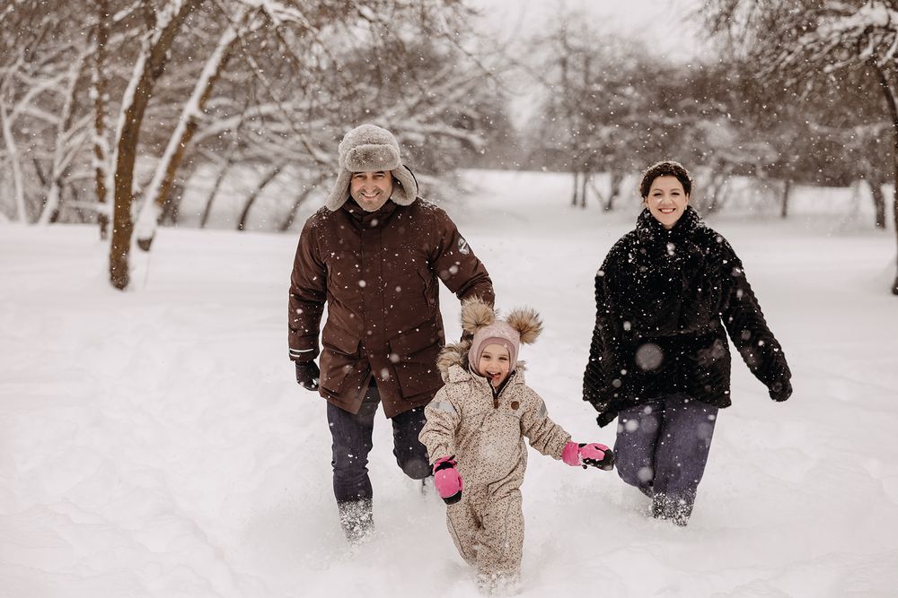 Family in winter outfits in the snow
