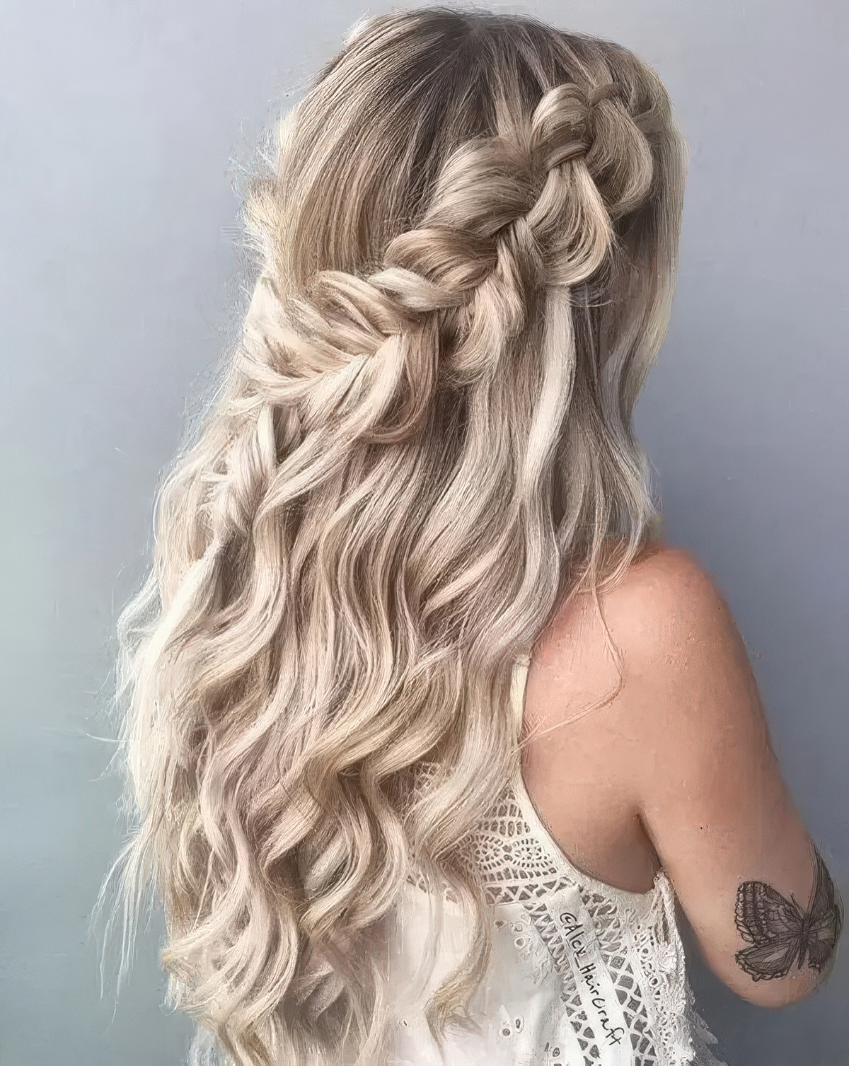 Half-up hairstyle with large loose braids on each side and flowing waves