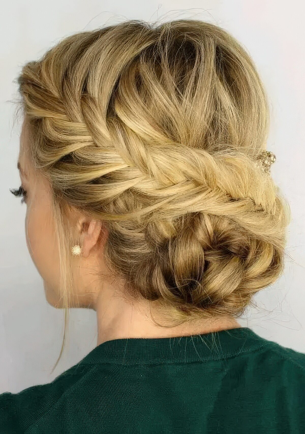 Blonde fishtail braid wrapped into a low bun updo