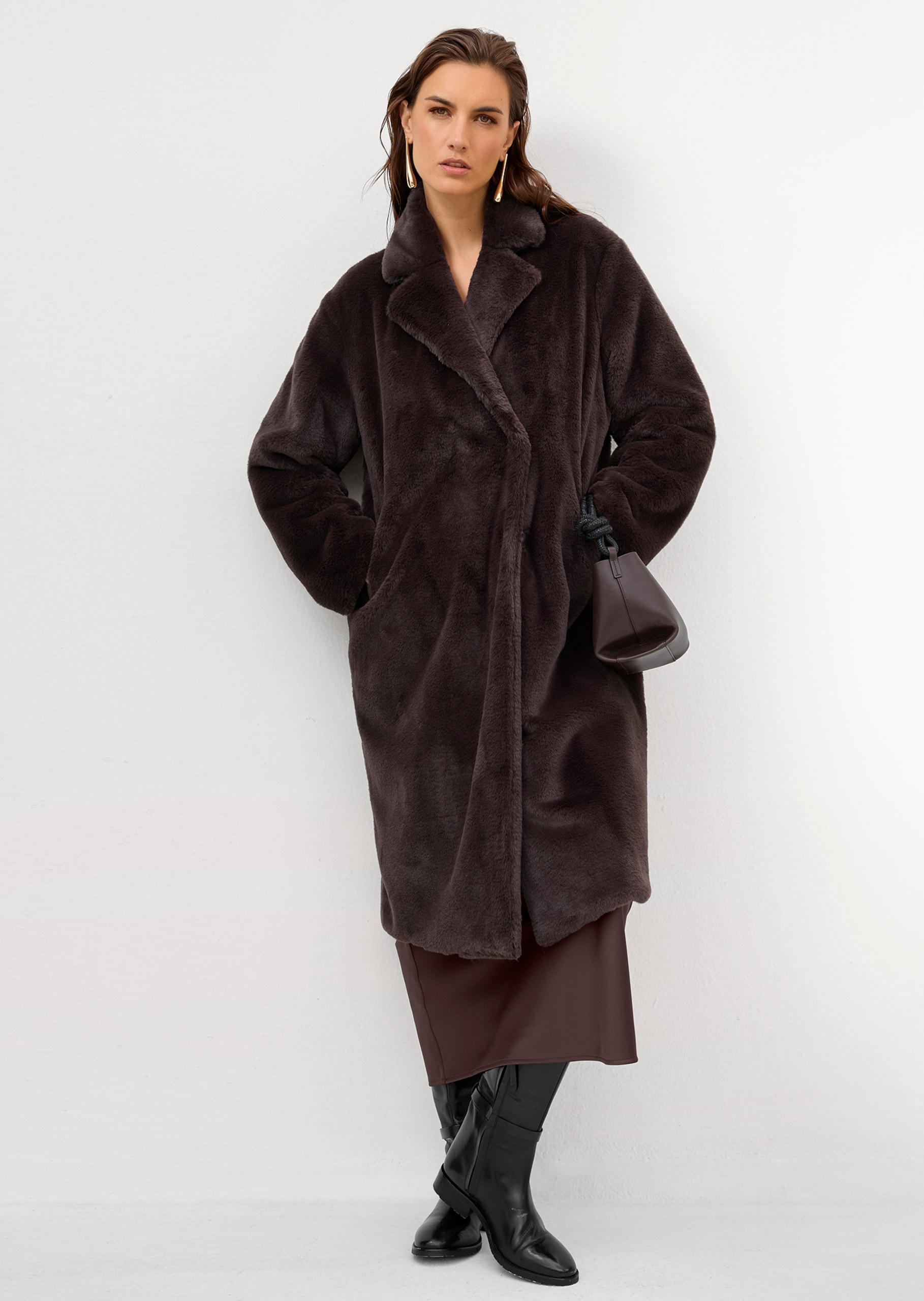 Dark brown faux fur coat with a brown satin skirt and black knee-high boots