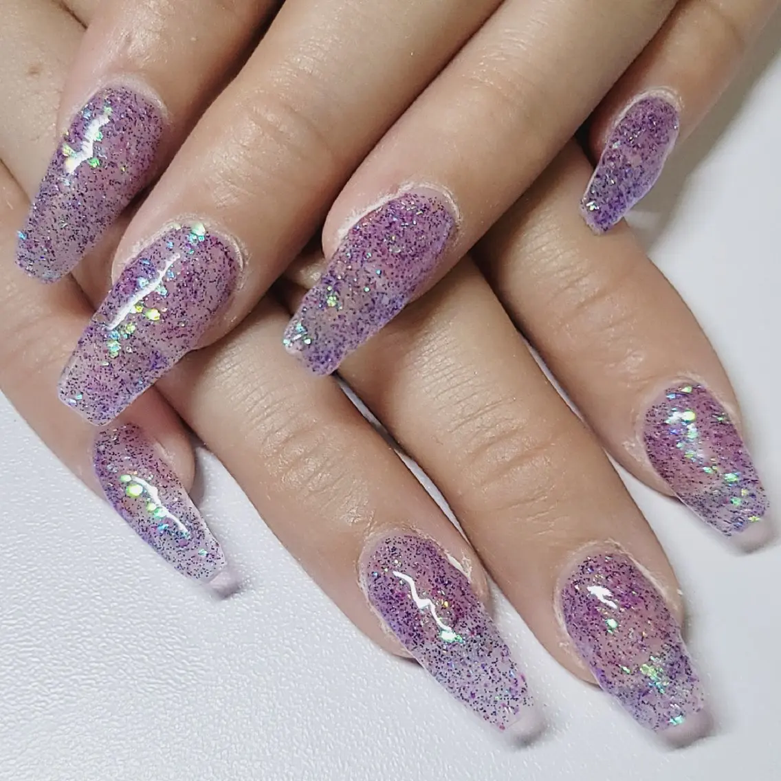 Long coffin nails in purple holographic glitter