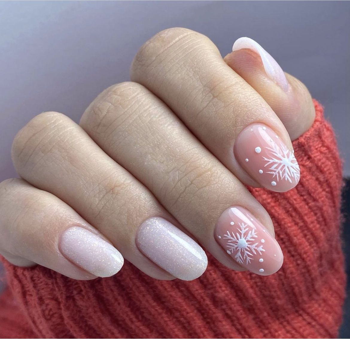 Nude nails with white snowflake accent nail art