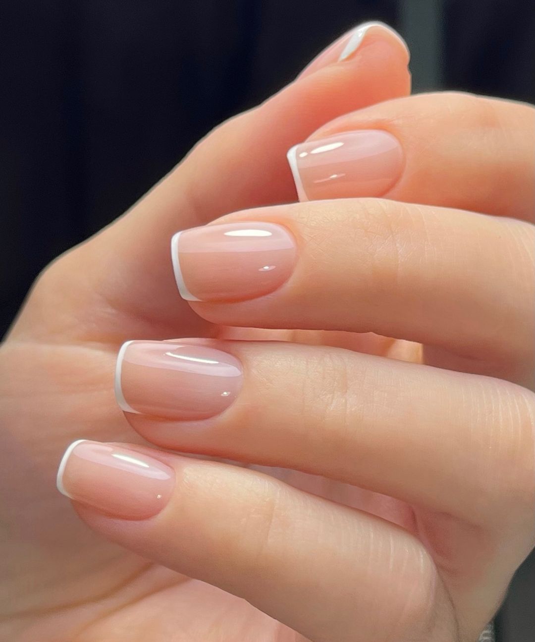 Short square white French tips on nude nails
