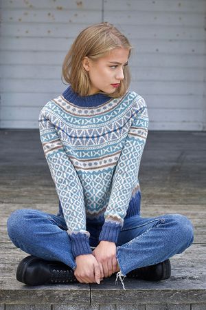 Woman wearing a blue and white Nordic fair-isle knit sweater with jeans