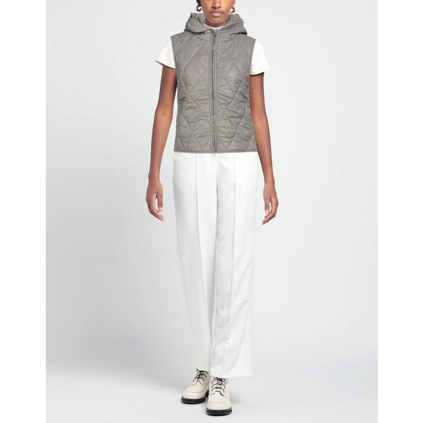Woman layering a quilted vest over a hoodie with wide-leg trousers