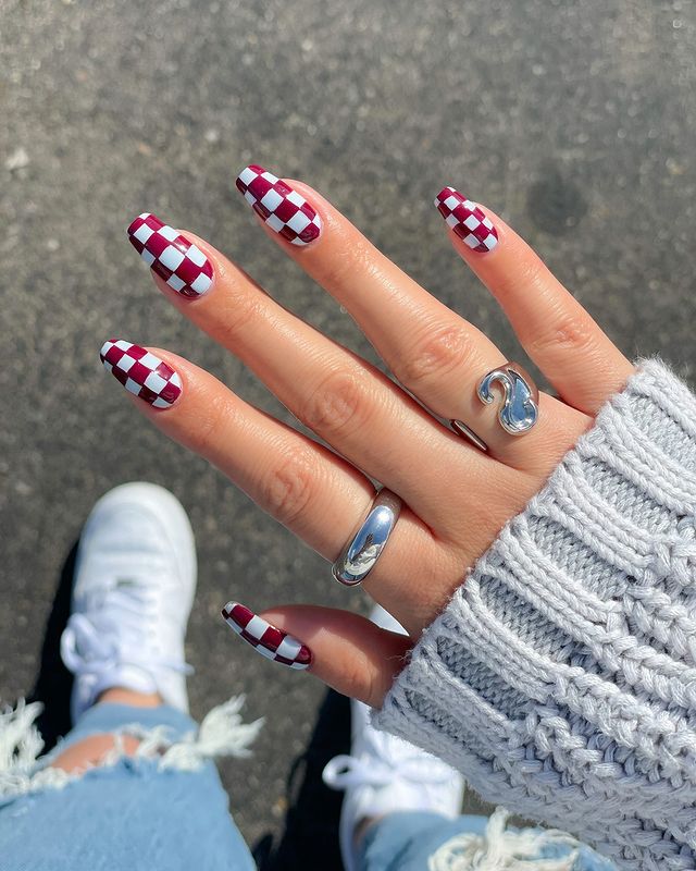 Almond nails with burgundy and white checkered nail art