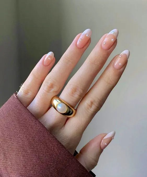 Nude french tip nails with tiny micro-pearls scattered across the nails