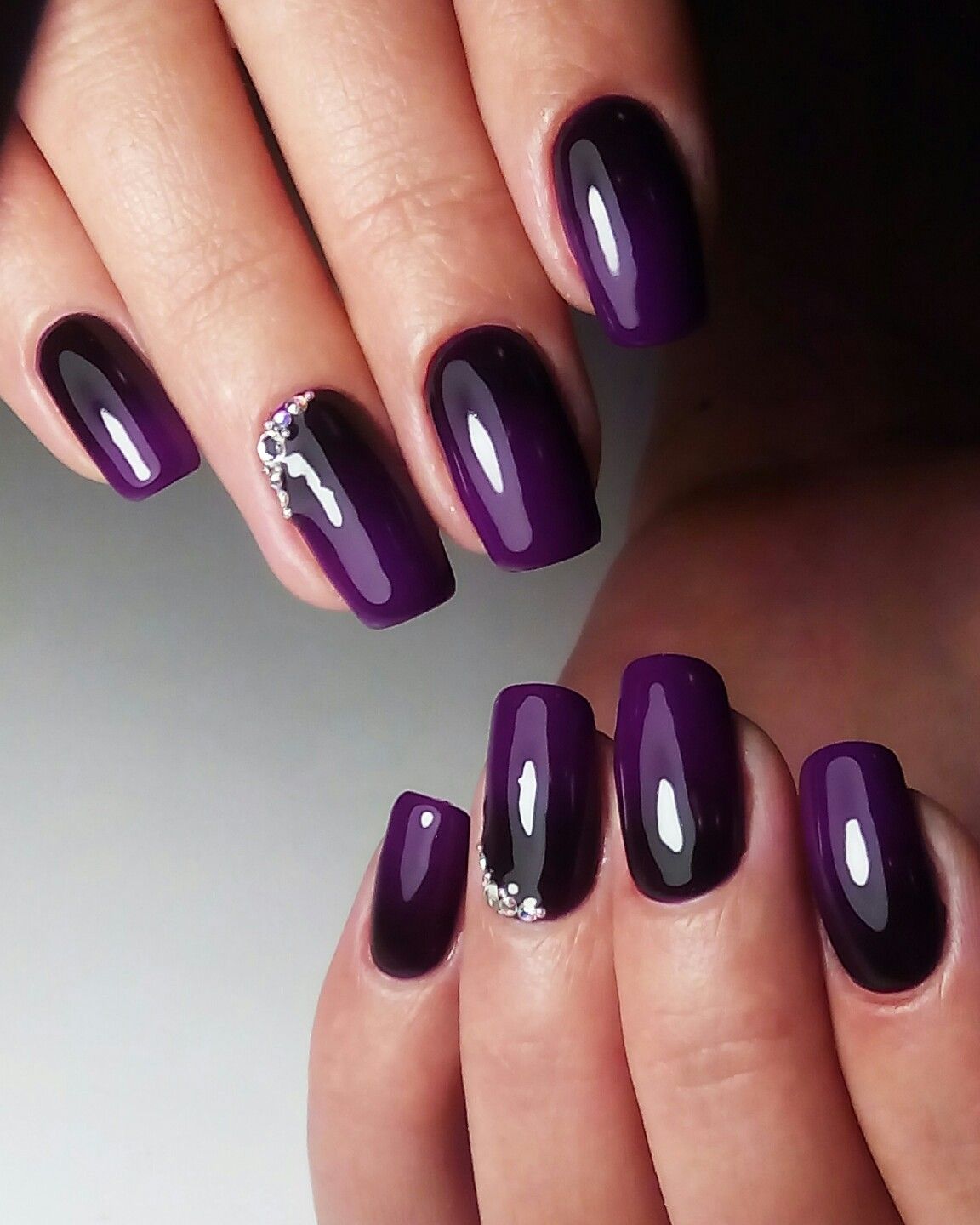 Deep purple nails with crystal accent at the cuticle