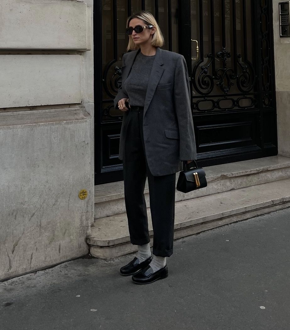 Woman wearing a tonal grey layered winter outfit with grey loafers