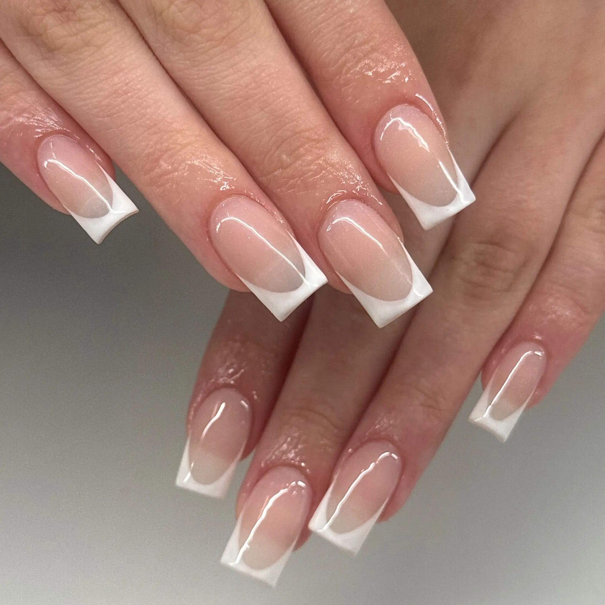 Classic white French tip manicure on square nails from a nail salon