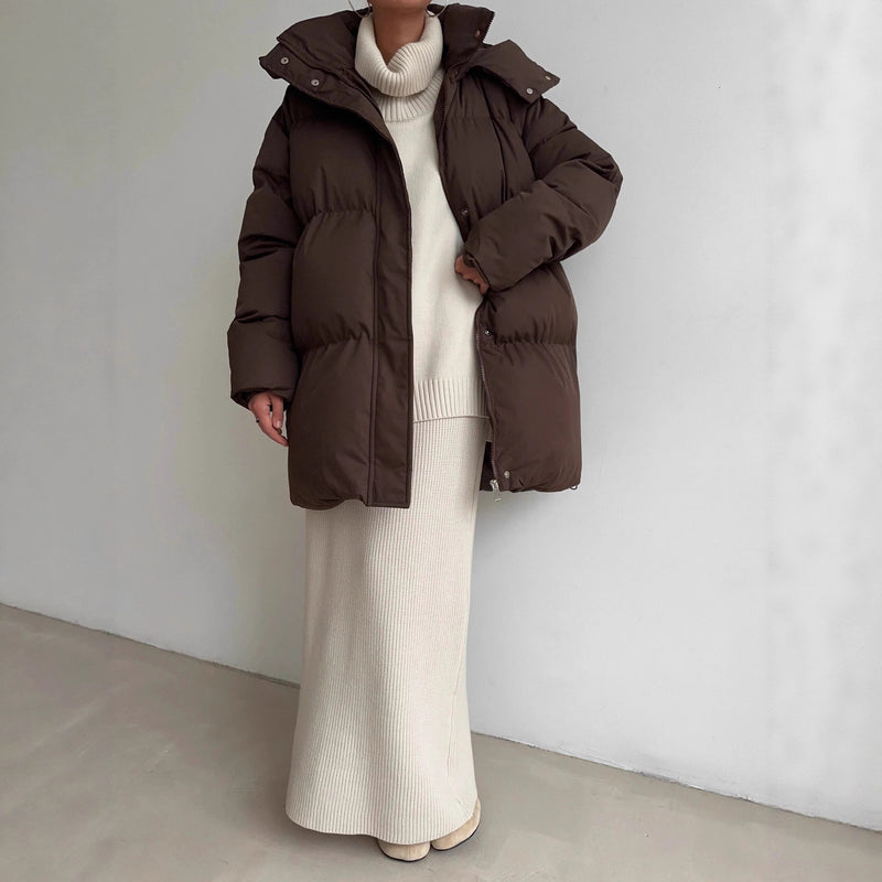 Woman in a longline puffer coat with a knit midi skirt