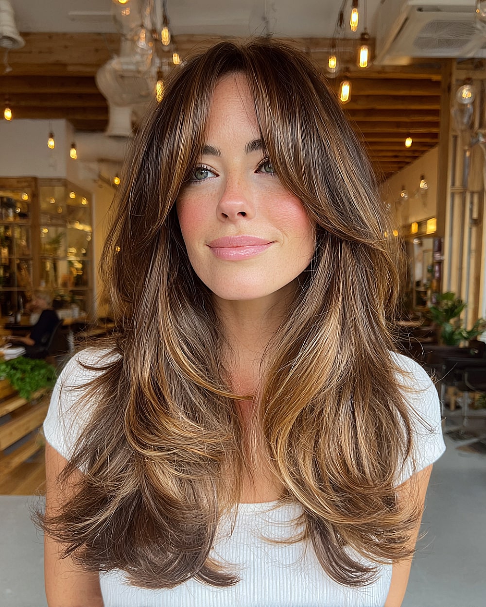 Long layered hair with curtain bangs and ash brown balayage highlights