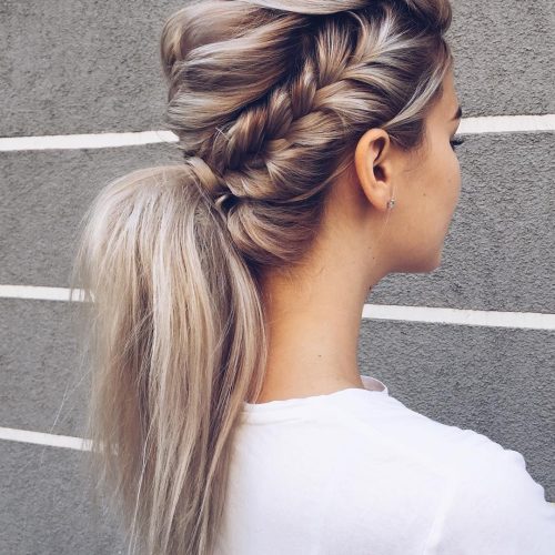 Woman with an ash-blonde fishtail braid flowing into a low ponytail
