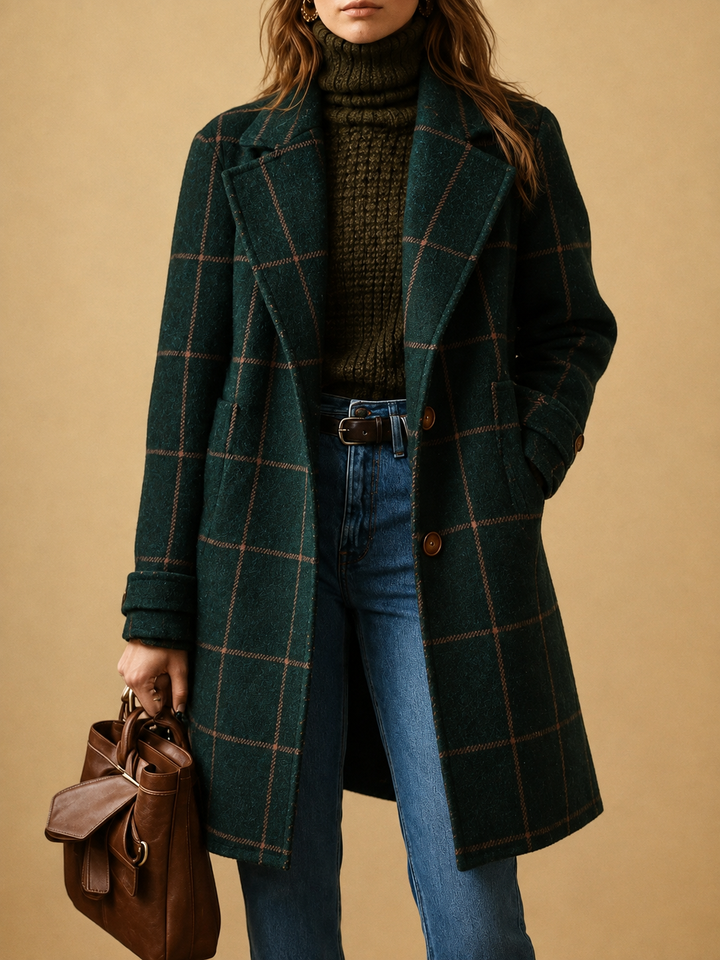 Woman in a dark green check coat with an olive turtleneck, blue jeans and a brown leather bag