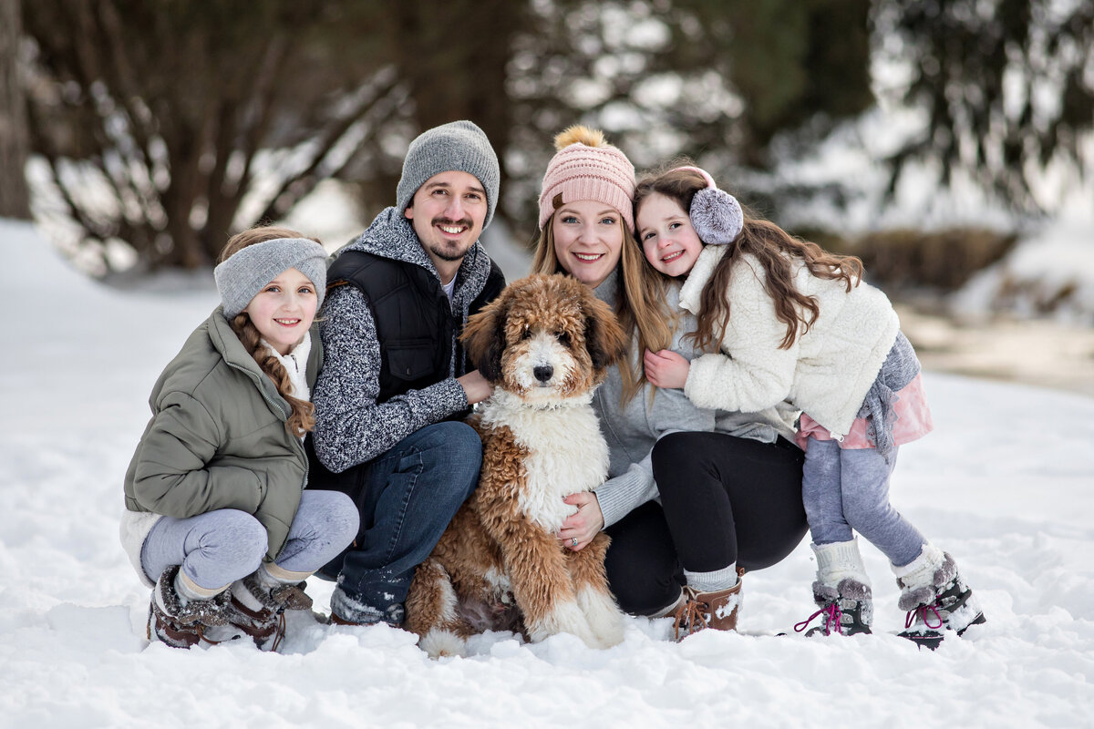 Family with their dog in coordinated winter outfits