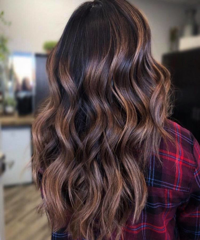 Long wavy hair melting from dark espresso roots to caramel ends