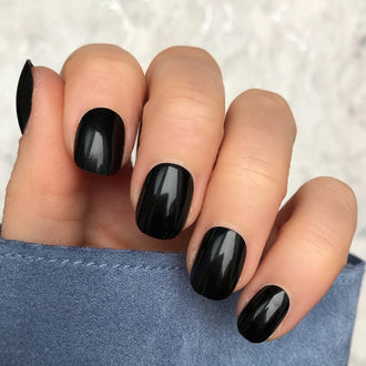 Short round nails painted in glossy pure black