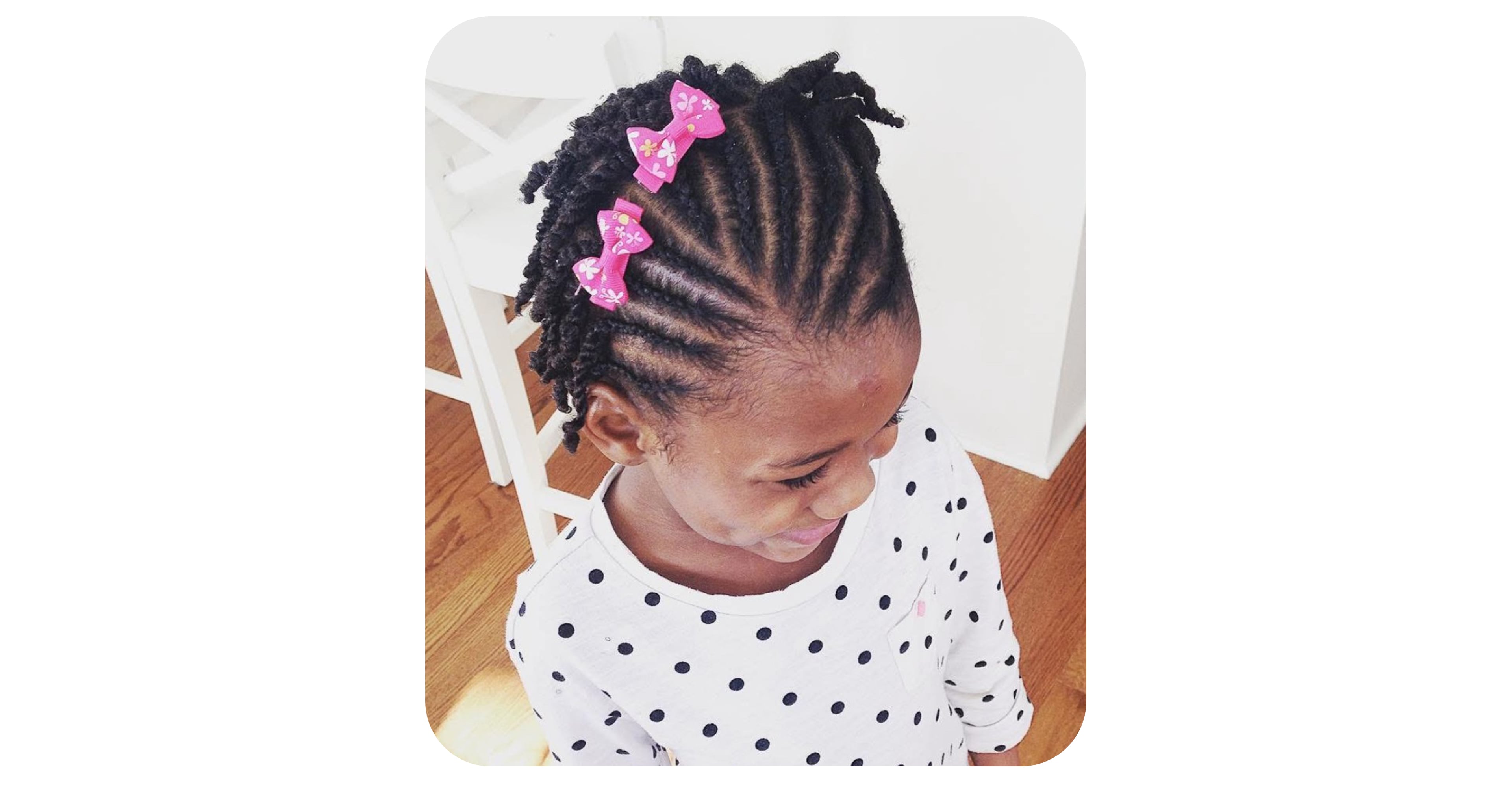 Toddler with cornrows flowing into twists, finished with pink bow clips