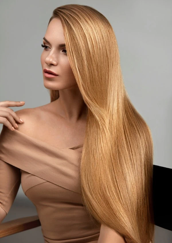 Woman with honey blonde long layered hair worn straight