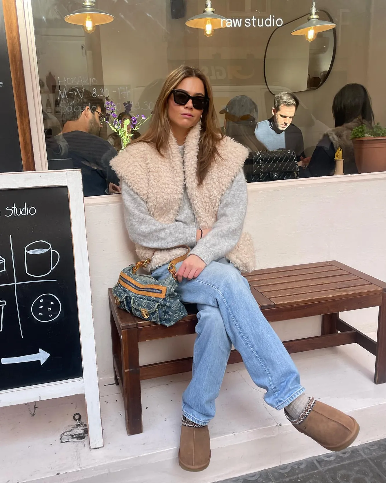 Woman wearing Ugg mini platform boots with a faux shearling gilet vest and straight-leg jeans