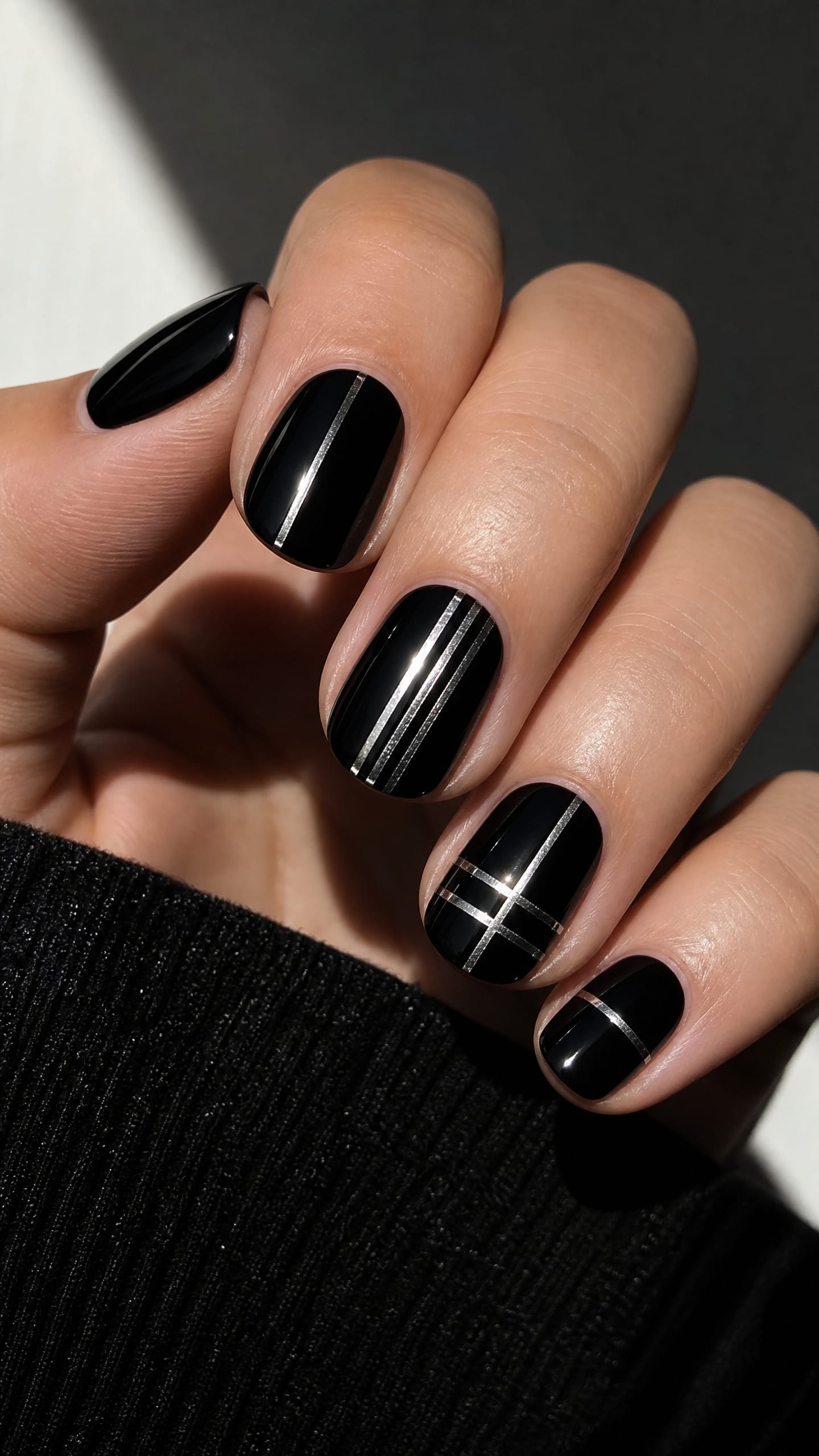 Glossy black nails with a single thin silver line accent