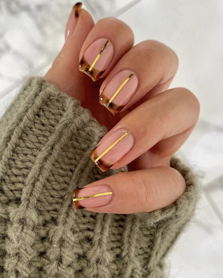 Nude-pink square nails with tortoiseshell French tips and thin gold striping lines